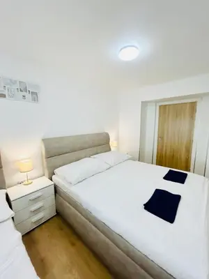 a bedroom with a large white bed and a night stand at A newly renovated Apartment the heart of Prague in Prague