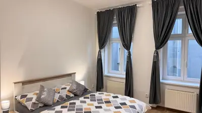 a bedroom with a bed and two windows at Apartmnet near IP Pavlova in Prague