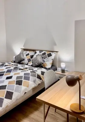 a bedroom with a bed and a wooden table at Apartmnet near IP Pavlova in Prague