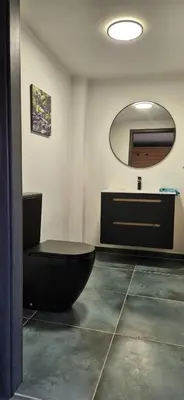 a bathroom with a black toilet and a sink at Private House with Sauna, Jacuzzi and Hawaiian Hothouse Spa in Velvary