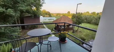 a balcony with a table and chairs and a house at Private House with Sauna, Jacuzzi and Hawaiian Hothouse Spa in Velvary
