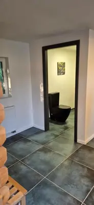 a bathroom with a black toilet in a room at Private House with Sauna, Jacuzzi and Hawaiian Hothouse Spa in Velvary