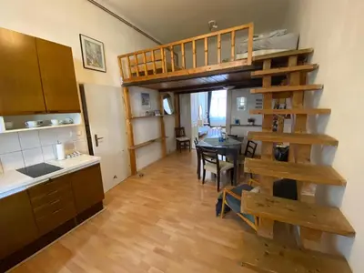 a kitchen with a loft bed and a dining room at Prague charming flat old Vinohrady in Prague