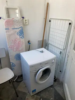a washing machine in a laundry room with a refrigerator at Prague charming flat old Vinohrady in Prague