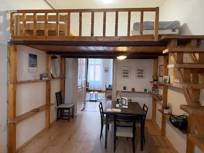 a room with a dining table and a loft bed at Prague charming flat old Vinohrady in Prague
