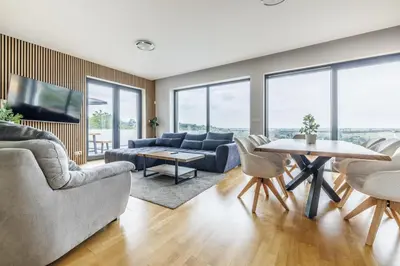 a living room with a couch and a table at Airport Prague Luxury Apartment & Spa in Prague
