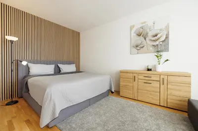 a bedroom with a bed and a wooden dresser at Airport Prague Luxury Apartment & Spa in Prague