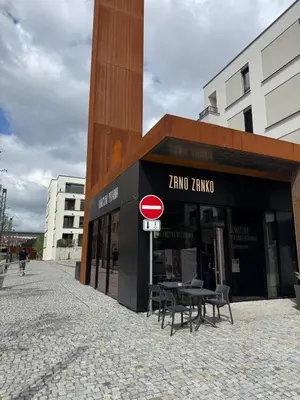 a store with tables and chairs in front of a building at Prague's Bohemian Grey in Prague
