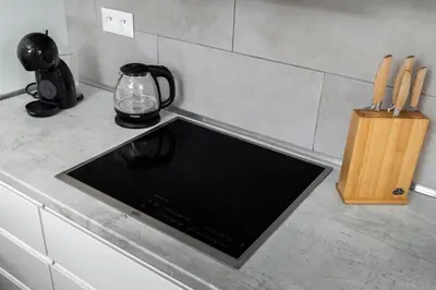 a kitchen counter with a stove top oven and a knife block at Home for Successful Businessman in Prague