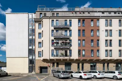 an apartment building with cars parked in a parking lot at Home for Successful Businessman in Prague