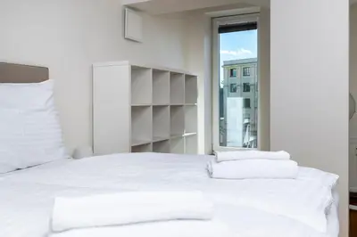 a white bed with white pillows and a window at Home for Successful Businessman in Prague
