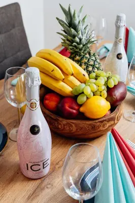 a table with a basket of fruit and a bottle of wine at Royal Elephant Residence in Prague