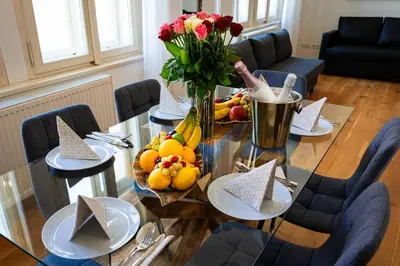 a glass table with a vase of flowers and fruit on it at Big Cat Residence in Prague