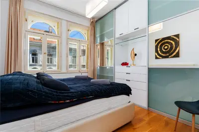 a bedroom with a bed and two windows at Big Cat Residence in Prague