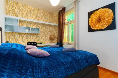 a bedroom with a blue bed with purple pillows at Big Cat Residence in Prague