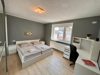 a bedroom with a bed and a desk and a desk at Apartmán u zámeckého parku in Všestudy