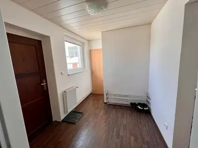 an empty room with a door and a wooden floor at Apartmán u zámeckého parku in Všestudy