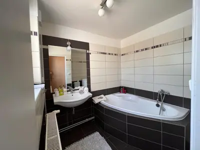 a bathroom with a tub and a sink at Apartmán u zámeckého parku in Všestudy