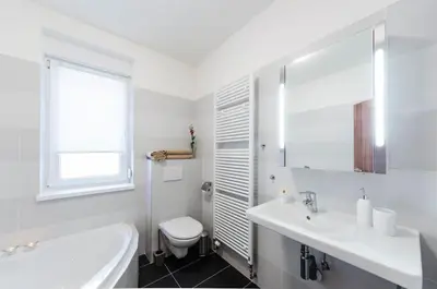 a white bathroom with a sink and a toilet at Pension Zličín in Prague