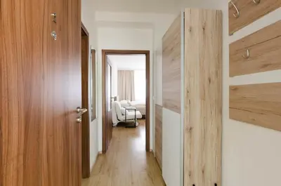 a hallway with a door and a chair in a room at Pension Zličín in Prague