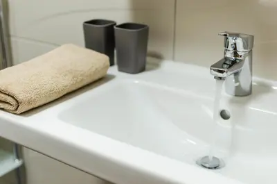 a bathroom sink with a towel and a faucet at Pension Zličín in Prague