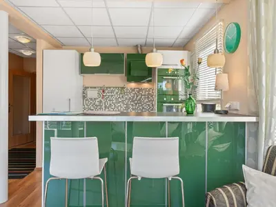 a kitchen with green cabinets and white stools at Apartment U Rybníka by Interhome in Stříbrná Skalice
