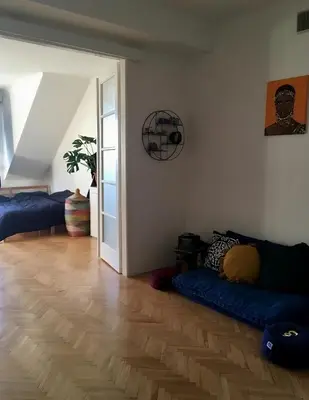 a living room with a blue couch on a wooden floor at Bright and calm flat in Prague