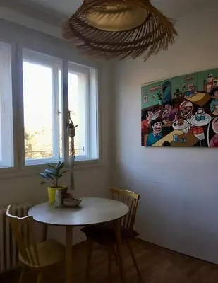 a dining room with a table and a painting on the wall at Bright and calm flat in Prague