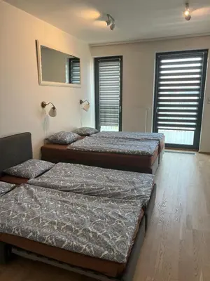 two beds in a room with two windows at New brand studio in Prag with parking in Prague