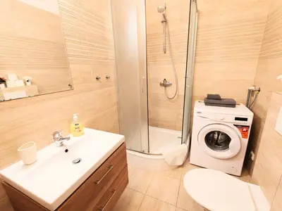 a bathroom with a sink and a washing machine at Comfy place in Prague