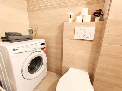 a bathroom with a washing machine and a toilet at Comfy place in Prague