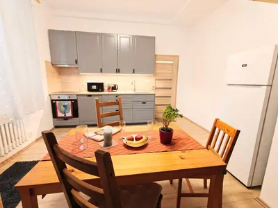 a kitchen with a wooden table with chairs and a dining room at Comfy place in Prague