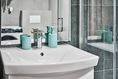 a bathroom with a white sink and a shower at Sokolska apartment in Prague