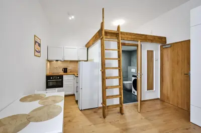 a small kitchen with a ladder in a tiny apartment at Sokolska apartment in Prague