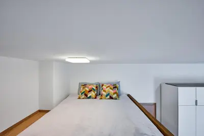a bed in a room with white walls at Sokolska apartment in Prague