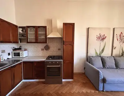 a kitchen with a stove and a couch in a room at 1920s Charm apartment by Jerusalem Synagogue in Old Town Center in Prague