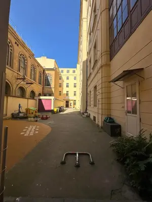 an empty alley between two buildings with a cart on the ground at 1920s Charm apartment by Jerusalem Synagogue in Old Town Center in Prague