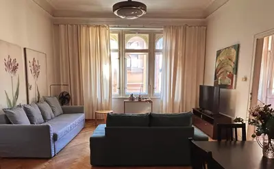 a living room with a couch and a tv at 1920s Charm apartment by Jerusalem Synagogue in Old Town Center in Prague