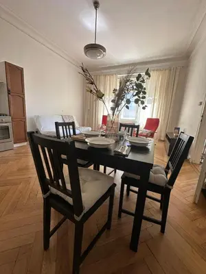 a dining room table and chairs in a living room at 1920s Charm apartment by Jerusalem Synagogue in Old Town Center in Prague