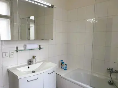 a bathroom with a sink and a tub and a mirror at Affordable Top floor 2BR nightlife location in Center and yet Quite Sleep in Prague