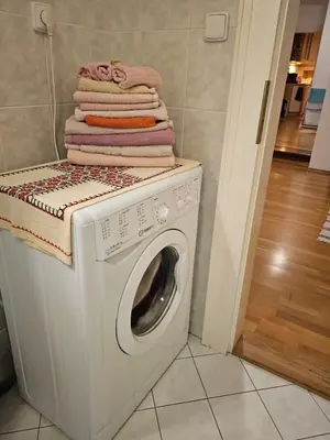 a washing machine with a stack of towels on top at 2 min Center Just In, Old Town Walk private room B in Prague