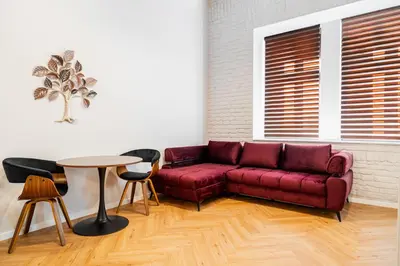 a living room with a red couch and a table at LuxeLoftPrague in Prague