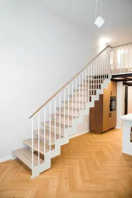 a white staircase in a room with wooden floors at LuxeLoftPrague in Prague