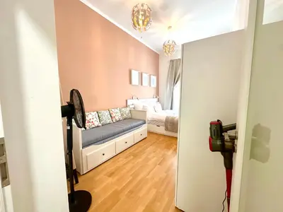 a bedroom with two beds and a fan at Golden Dome Skyline Retreat Modern 2BR Apartment in Prague 1 Center with King Bed and Museum View in Prague