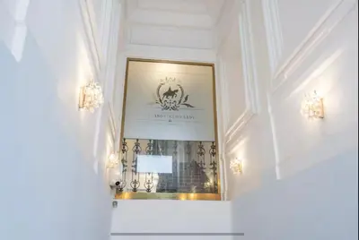 a hallway with a staircase leading to a large door at Golden Dome Skyline Retreat Modern 2BR Apartment in Prague 1 Center with King Bed and Museum View in Prague
