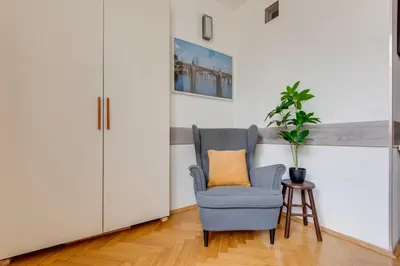 a blue chair with an orange pillow in a living room at Quaint Trendy Apartment in Prague