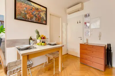 a kitchen with a table and a painting on the wall at Quaint Trendy Apartment in Prague