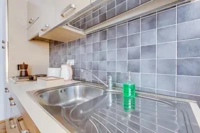 a kitchen sink with a green bottle on it at Quaint Trendy Apartment in Prague