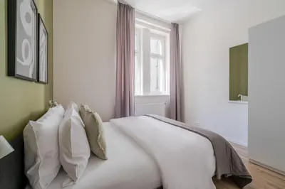 a table and two chairs in a room with windows at Blueground Holešovice view nr Vltava PRG-52 in Prague