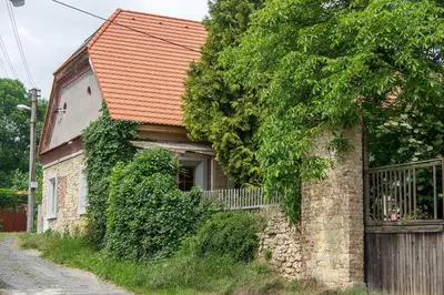 a brick building with an orange roof on a street at Very old house Ptice in Ptice